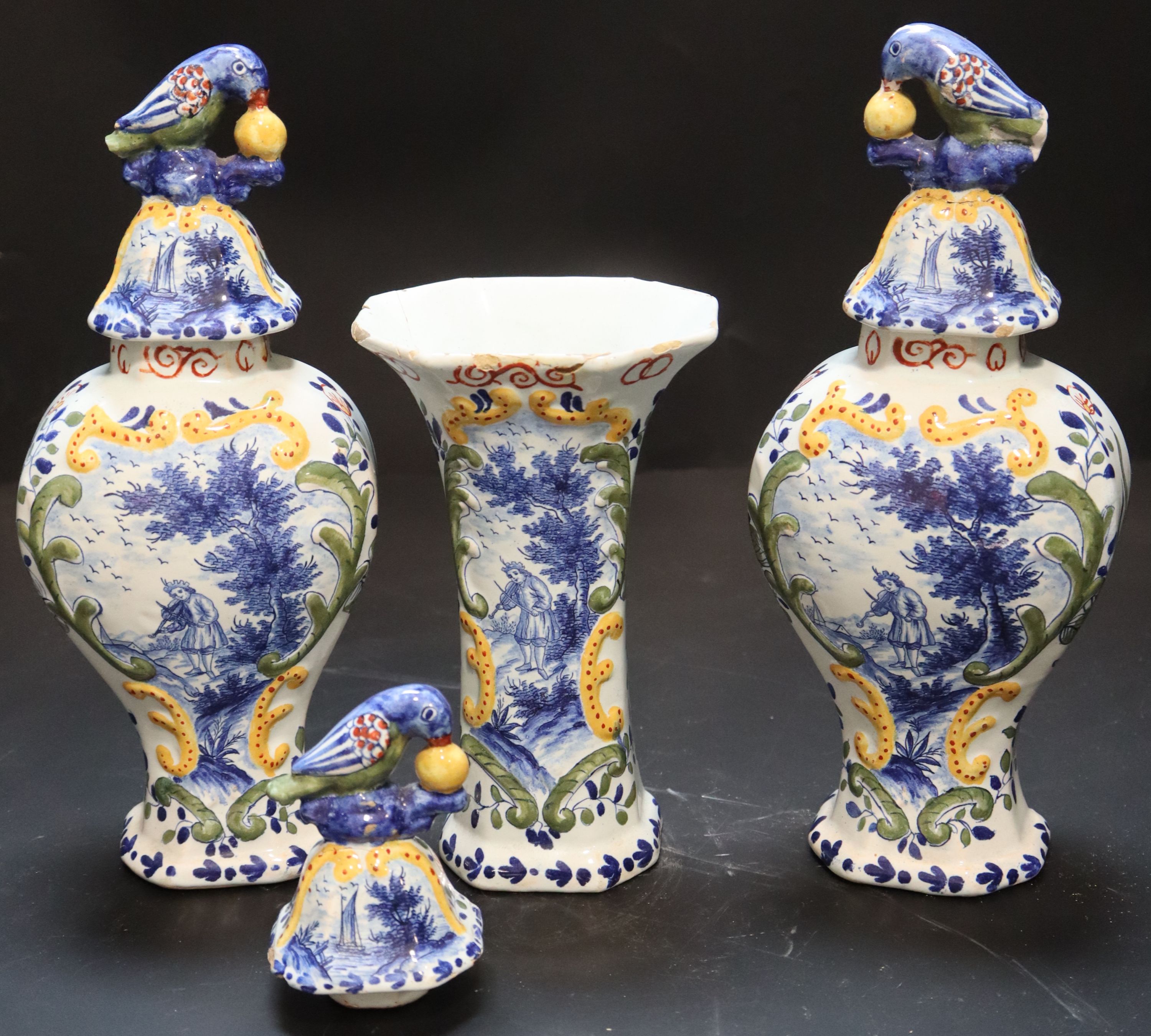 A 19th century Dutch delft polychrome part garniture of three vases, height 27cm and 19cm.